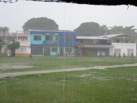 Kids playing fútbol in the Capurganá «square» under a heavy rain